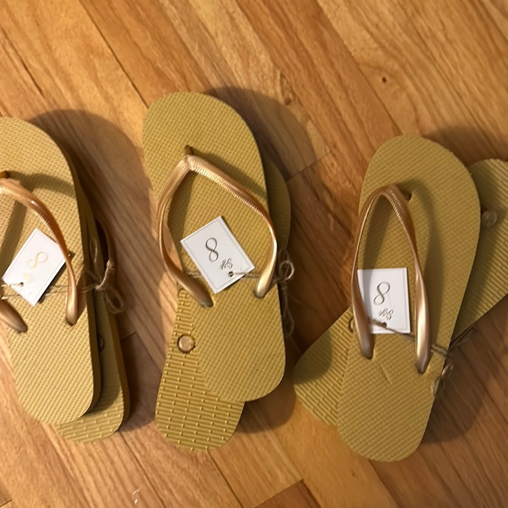 Three pairs of size 8 flip flops in a rich golden tannish color